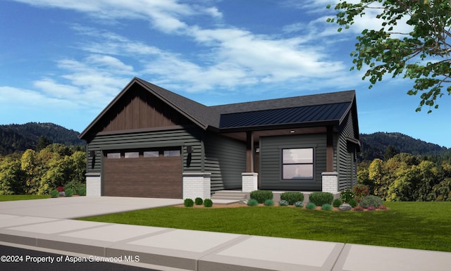 contemporary home with a front yard, a mountain view, and a garage