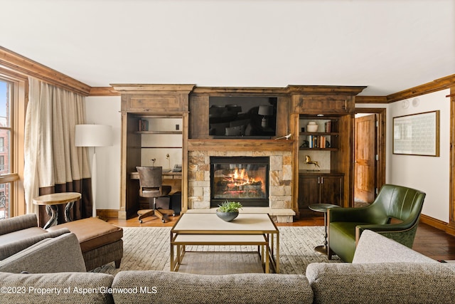 living room featuring hardwood / wood-style floors, ornamental molding, and a fireplace