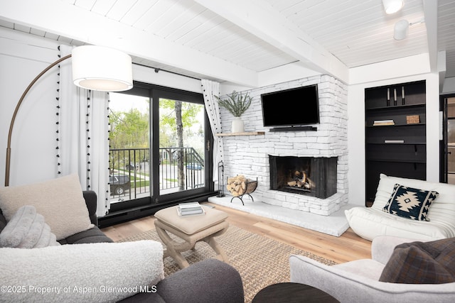 901 E Hyman Ave Unit 4, Aspen, CO 81611 - living area featuring wood finished floors, a stone fireplace, and wooden ceiling with exposed beams