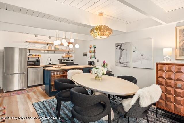 dining room featuring bar area, wooden ceiling, beamed ceiling, and light wood-style floors