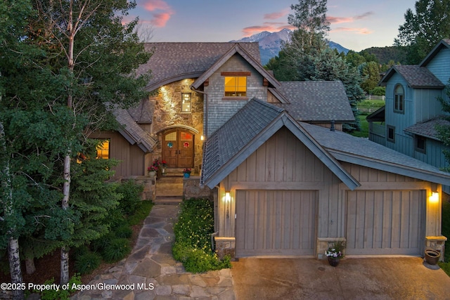 1185 Heritage Dr, Carbondale, CO 81623 - view of front of house with roof with shingles, driveway, stone siding, an attached garage, and a mountain view