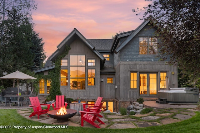 1185 Heritage Dr, Carbondale, CO 81623 - back of house at dusk featuring a hot tub, an outdoor fire pit, and a patio area
