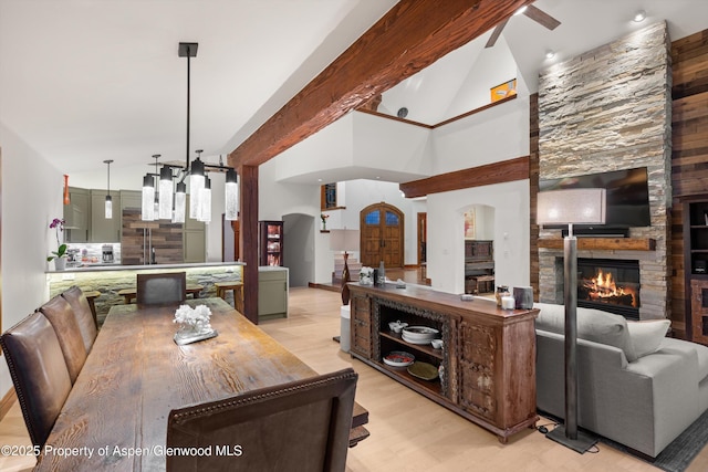 1185 Heritage Dr, Carbondale, CO 81623 - dining room with arched walkways, a stone fireplace, light wood finished floors, beam ceiling, and high vaulted ceiling