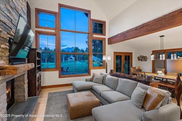1185 Heritage Dr, Carbondale, CO 81623 - living area featuring high vaulted ceiling, french doors, a large fireplace, wood finished floors, and beam ceiling