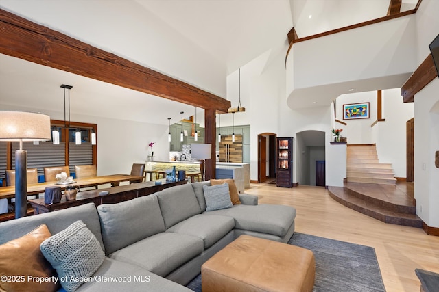1185 Heritage Dr, Carbondale, CO 81623 - living area with arched walkways, light wood-style floors, stairs, and a high ceiling