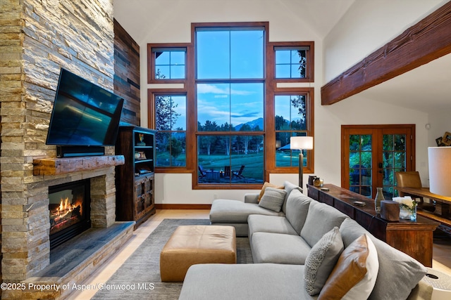 1185 Heritage Dr, Carbondale, CO 81623 - living room featuring high vaulted ceiling, a stone fireplace, wood finished floors, beamed ceiling, and healthy amount of natural light