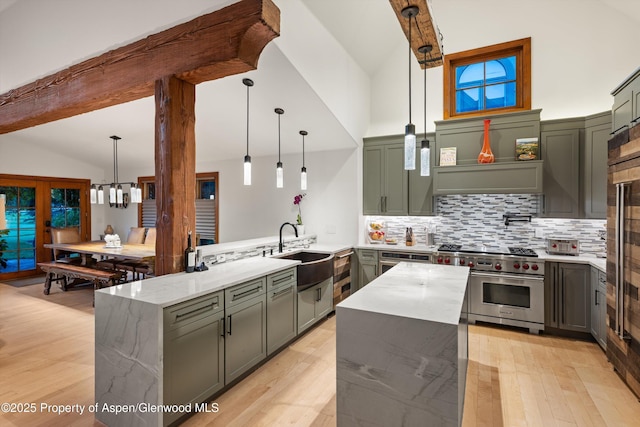 1185 Heritage Dr, Carbondale, CO 81623 - kitchen featuring premium range, light stone counters, green cabinetry, tasteful backsplash, and a peninsula
