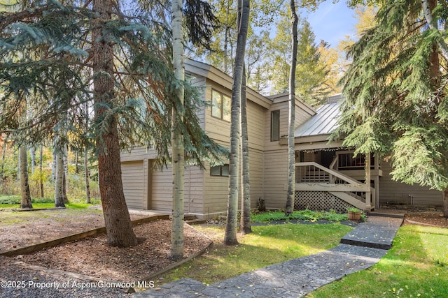 645 Sneaky Ln, Aspen, CO 81611 - view of home's exterior with metal roof, a standing seam roof, and a garage