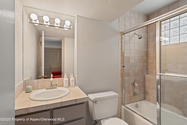 645 Sneaky Ln, Aspen, CO 81611 - full bath featuring combined bath / shower with glass door, vanity, a textured wall, toilet, and a textured ceiling