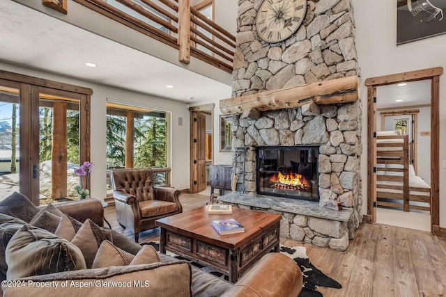 living room featuring a fireplace, a towering ceiling, and hardwood / wood-style flooring