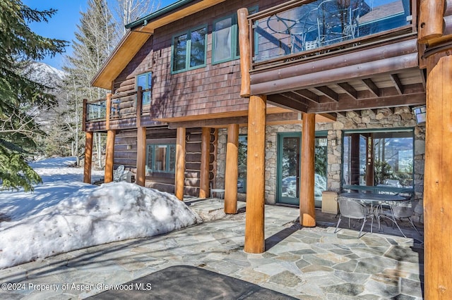 snow covered patio with a balcony