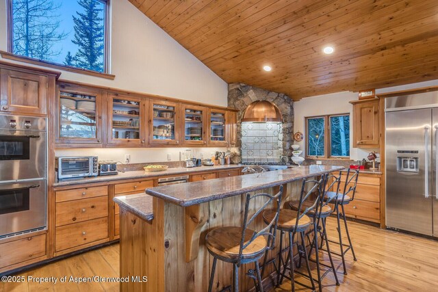 living room with a fireplace, high vaulted ceiling, and light hardwood / wood-style flooring