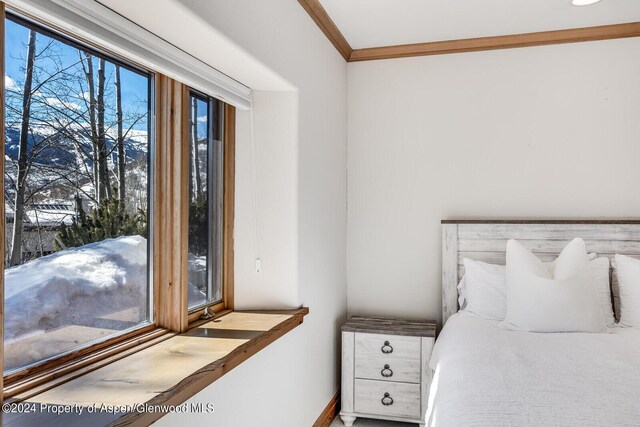 bedroom featuring ensuite bath, light carpet, and ornamental molding