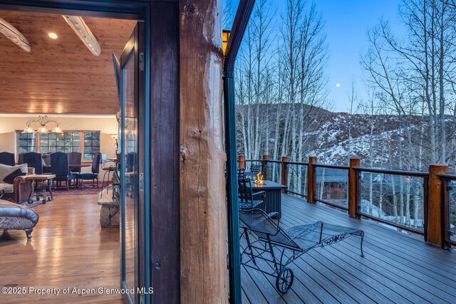 snow covered pool featuring a mountain view, a patio area, and an outdoor hot tub