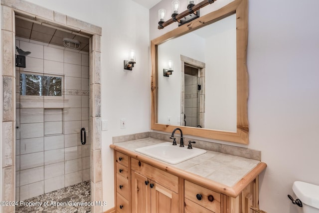 bathroom with vanity, toilet, and a shower with door