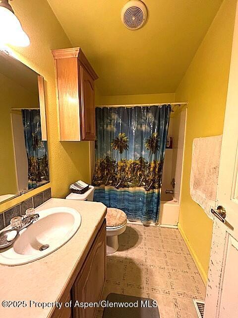 4050 County Road 7, Craig, CO 81625 - bathroom with vanity, toilet, shower / tub combo with curtain, and tile patterned flooring