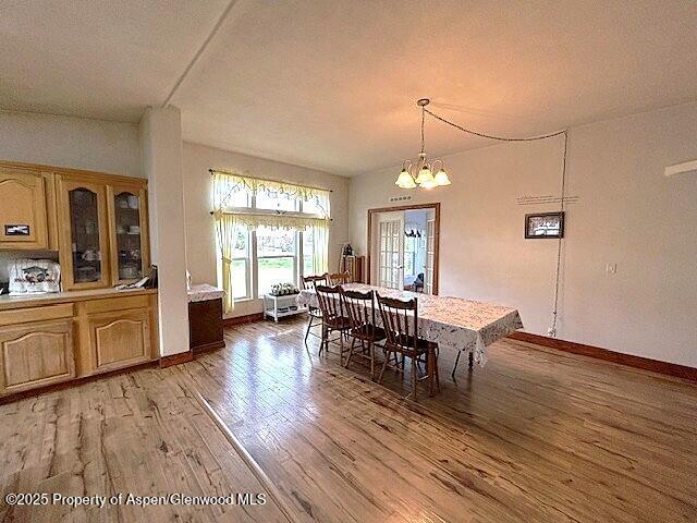 4050 County Road 7, Craig, CO 81625 - dining area featuring light wood-type flooring, a chandelier, and baseboards