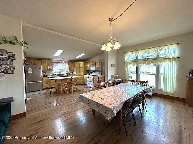 4050 County Road 7, Craig, CO 81625 - dining room with a chandelier, hardwood / wood-style floors, baseboards, and vaulted ceiling