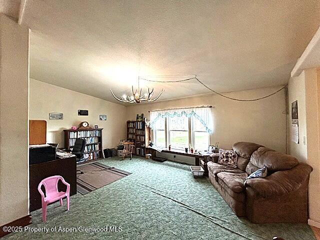 4050 County Road 7, Craig, CO 81625 - living area with a chandelier, carpet floors, and a textured ceiling
