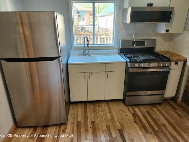 1004 Elm Ave, Collbran, CO 81624 - kitchen with stainless steel appliances, light wood finished floors, light countertops, and a sink