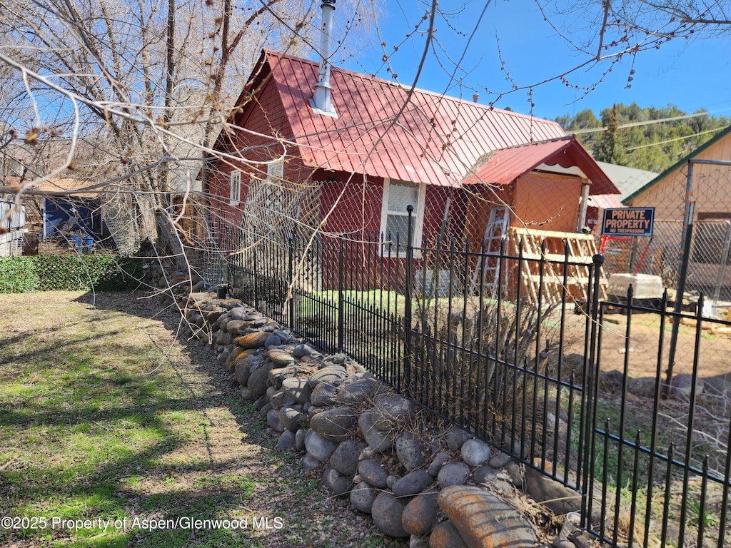 view of front of home featuring fence and metal roof