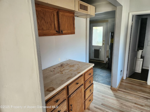 1004 Elm Ave, Collbran, CO 81624 - kitchen with light wood-type flooring, light countertops, and brown cabinetry