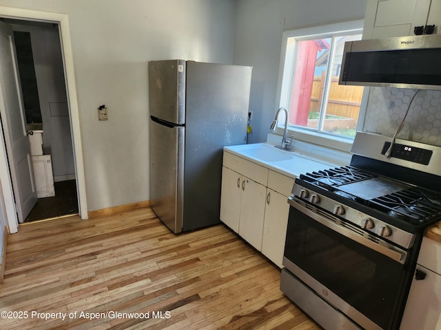 1004 Elm Ave, Collbran, CO 81624 - kitchen with appliances with stainless steel finishes, a sink, light wood-type flooring, and light countertops