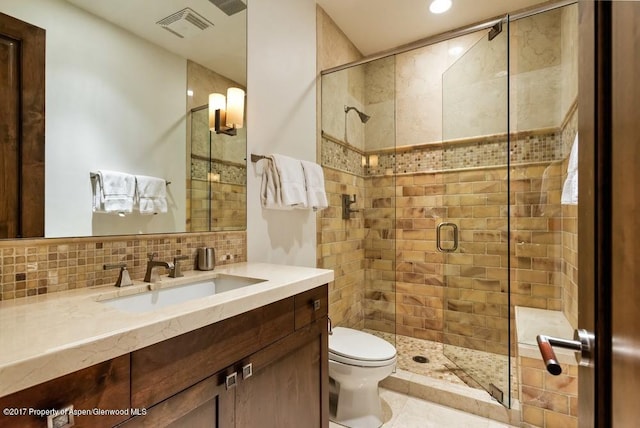 full bathroom featuring toilet, vanity, visible vents, a shower stall, and decorative backsplash