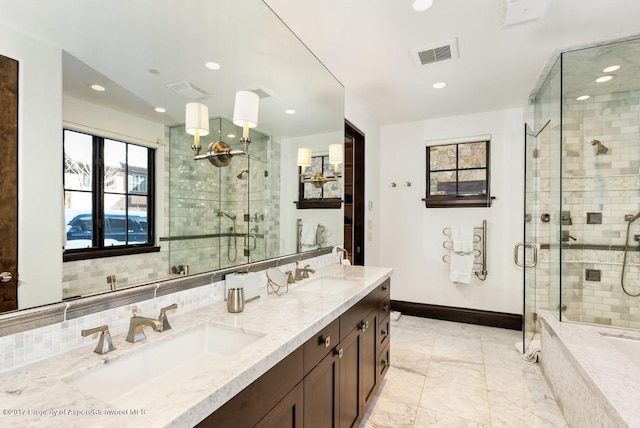 bathroom with a stall shower, a sink, and visible vents