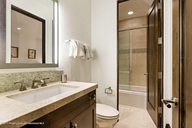 bathroom with bath / shower combo with glass door, decorative backsplash, toilet, tile patterned flooring, and vanity