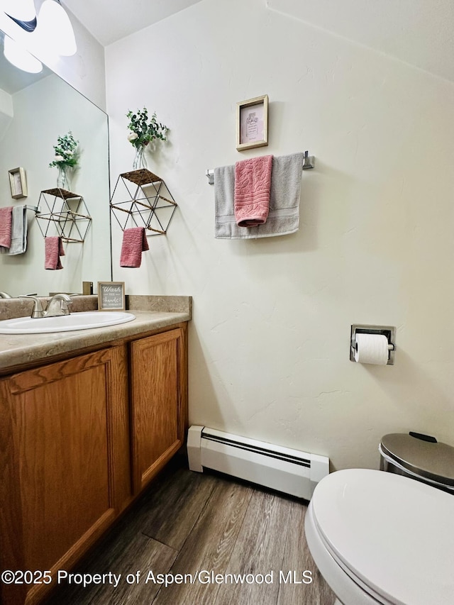 2529 Meadow Cir, Rifle, CO 81650 - bathroom featuring a baseboard heating unit, wood finished floors, and vanity