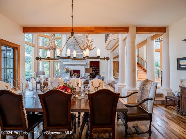 dining area featuring decorative columns, hardwood / wood-style floors, a chandelier, and beam ceiling