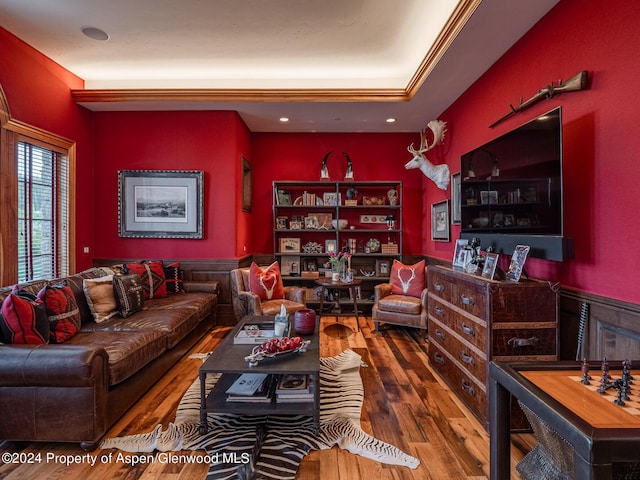 living room with wood-type flooring and ornamental molding