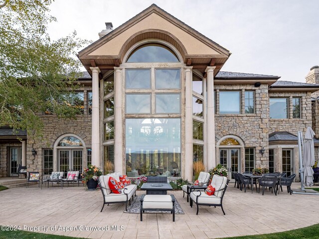 rear view of house featuring outdoor lounge area, french doors, and a patio