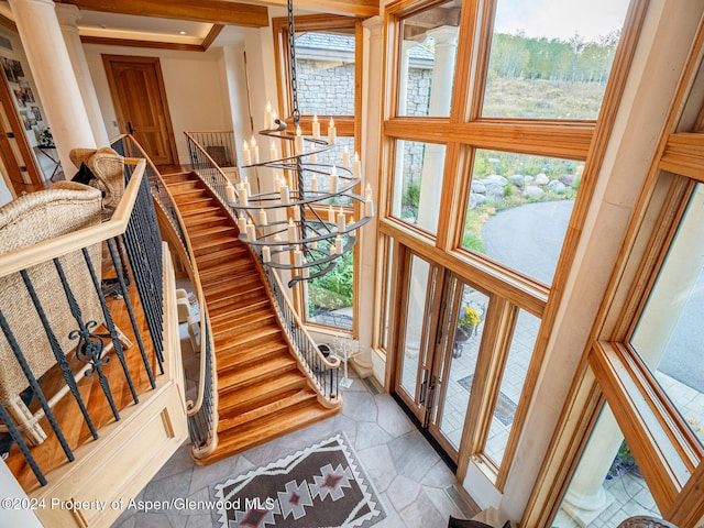 stairway with a towering ceiling and an inviting chandelier