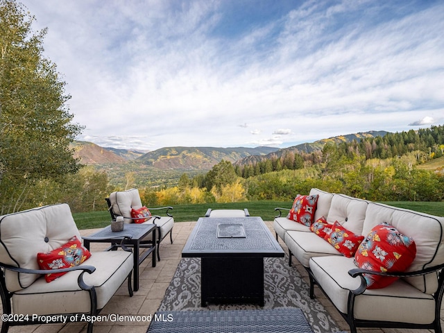 view of patio / terrace with a mountain view and an outdoor living space with a fire pit