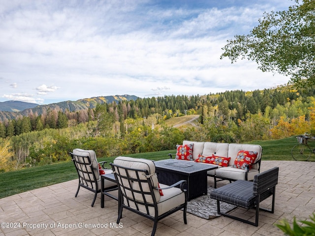 view of patio featuring a mountain view and an outdoor living space with a fire pit