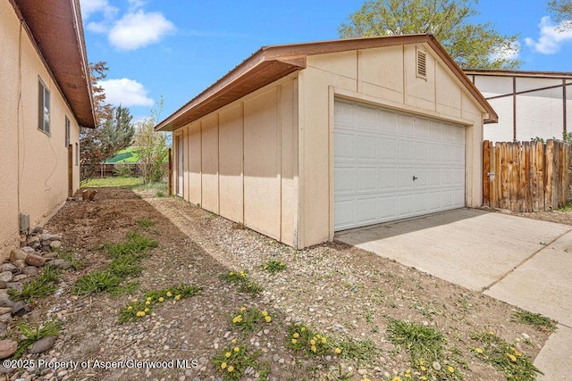 detached garage featuring fence