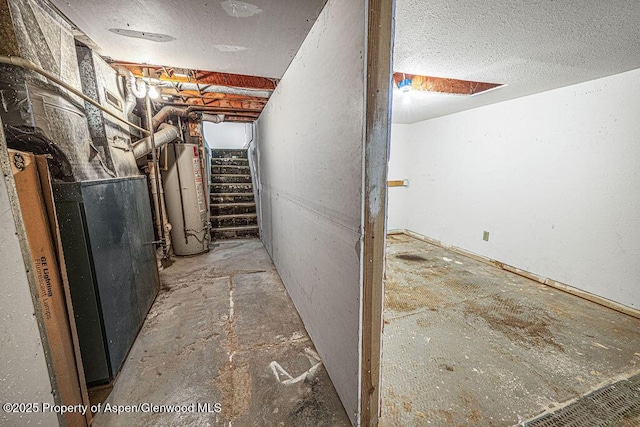 basement with heating unit, water heater, and a textured ceiling