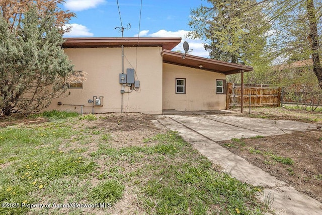 back of property with stucco siding, fence, and a patio area