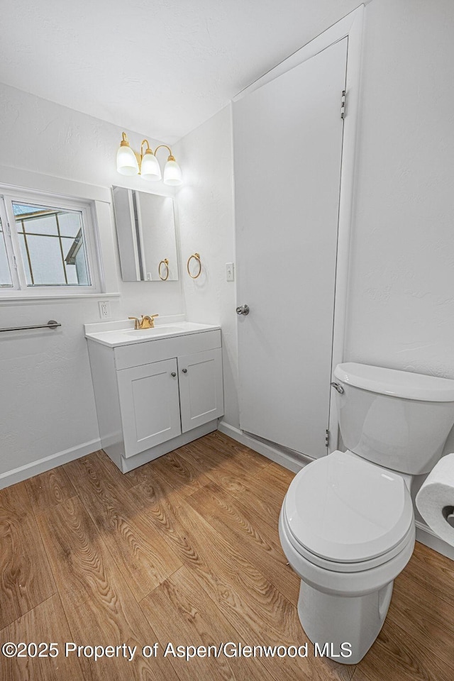 bathroom featuring vanity, hardwood / wood-style floors, and toilet