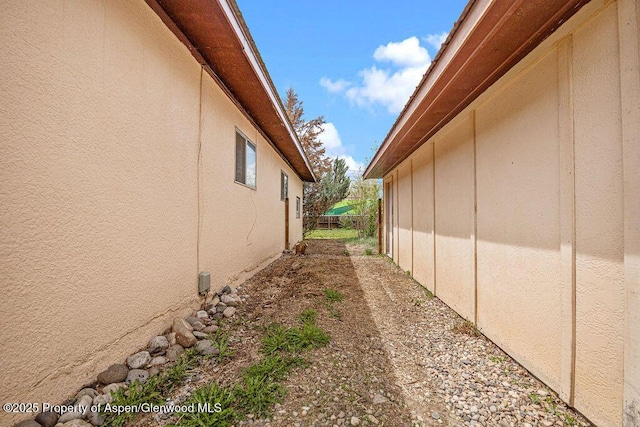 view of property exterior featuring stucco siding and fence