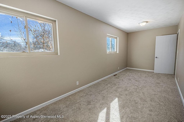 carpeted empty room with a textured ceiling