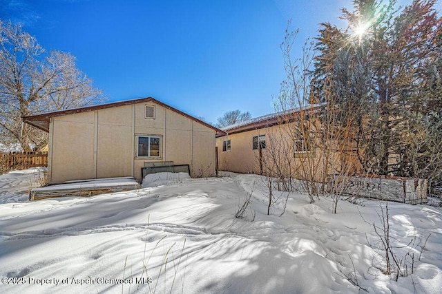 view of snow covered rear of property