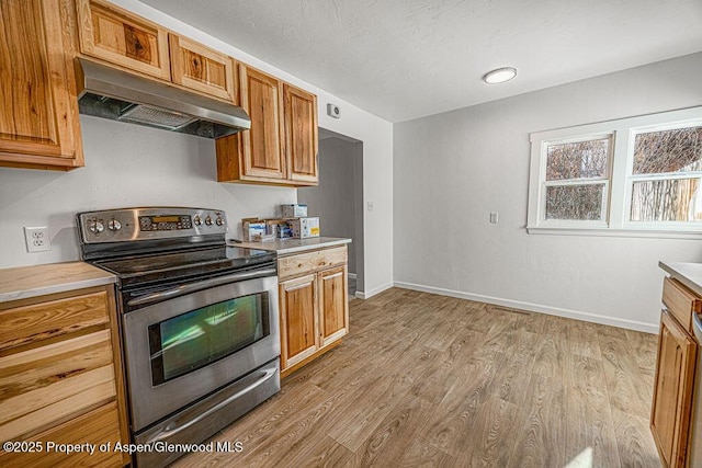 kitchen featuring extractor fan, light hardwood / wood-style flooring, stainless steel range with electric cooktop, and a textured ceiling