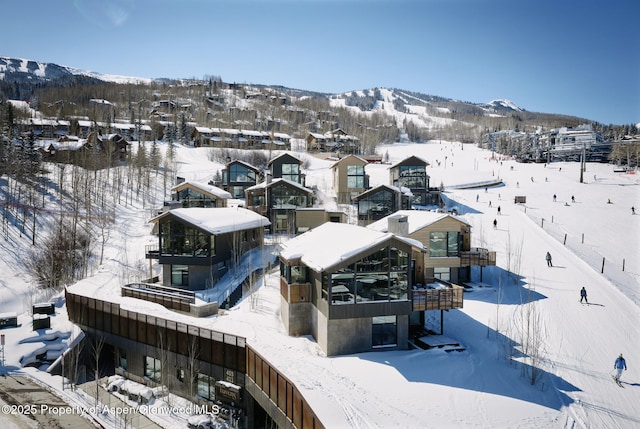 snowy aerial view featuring a residential view and a mountain view