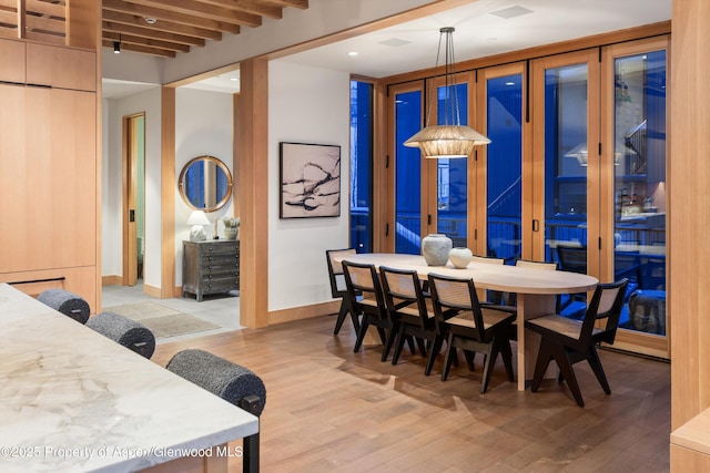 dining area featuring light wood-style flooring and baseboards