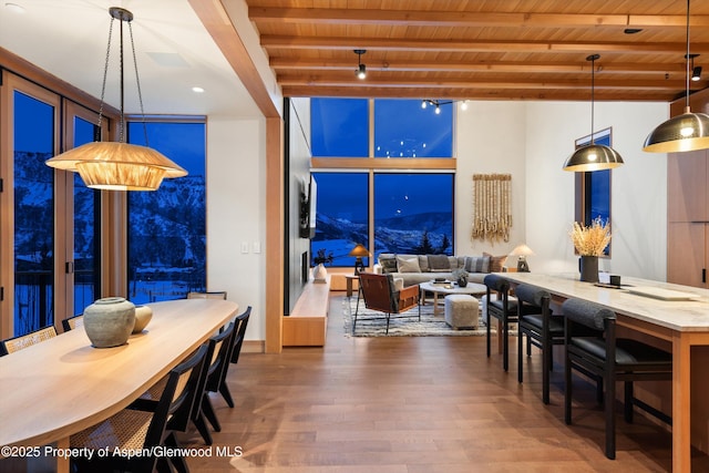 dining space with wooden ceiling, beam ceiling, and wood finished floors