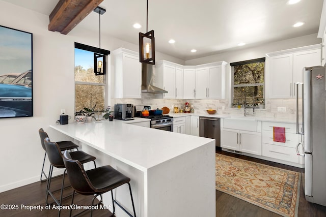 236 Paintbrush Way, Glenwood Springs, CO 81601 - kitchen with decorative backsplash, a peninsula, stainless steel appliances, recessed lighting, and wall chimney exhaust hood