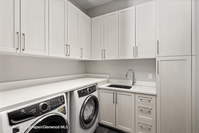 laundry area featuring sink, cabinets, and washer and dryer